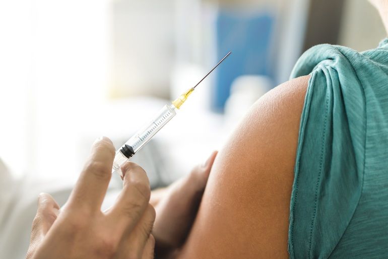 Vaccine_or_flu_shot_in_injection_needle._Doctor_working_with_patient's_arm._Physician_or_nurse_giving_vaccination_and_immunity_to_virus,_influenza_or_HPV_with_syringe._Appointment_with_medical_expert.