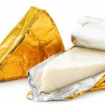 Cheese_triangle_in_foil_unpacked_close-up_on_a_white_background._Isolated