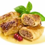 Stuffed_cabbage_rolls_with_sauce,_isolated_on_white_background