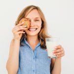 Playful_Woman_Holding_Glass_of_Milk_and_Cookie;_Shutterstock_ID_689900761;_PO:_redownload;_Job:_redownload;_Client:_redownload;_Other:_redownload
